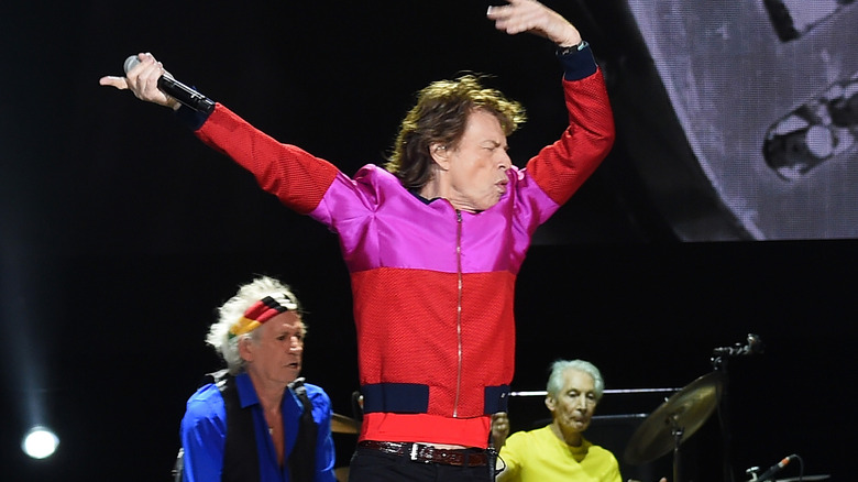 mick jagger on stage waving arms