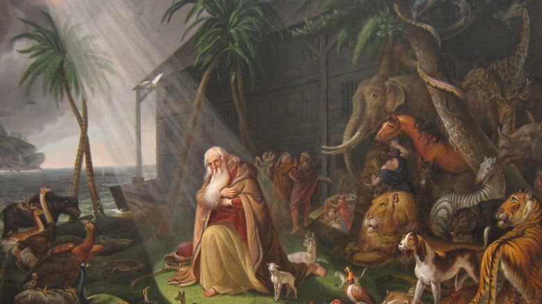 Noah kneeling in front of the ark and animals