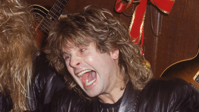 Ozzy Osbourne posing in front of a guitar and screaming