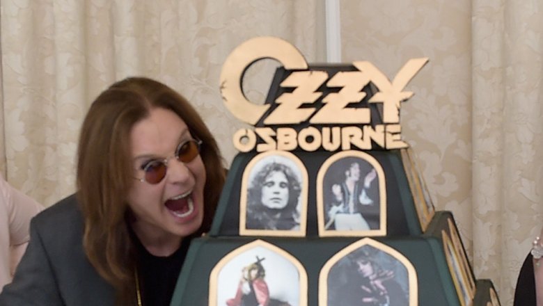 Ozzy Osbourne pretending to bite an elaborate cake