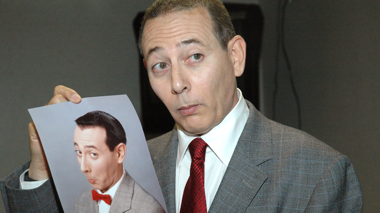 Paul Reubens holding a photo of Pee-wee Herman