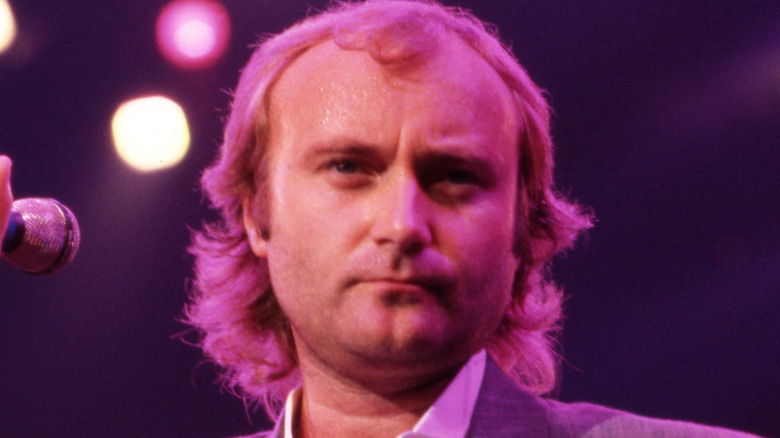 Phil Collins performing onstage in the 1980s