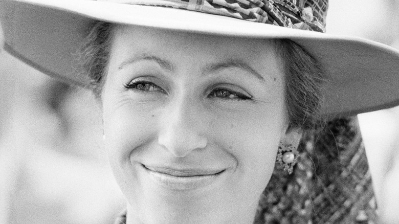 Princess Anne smiles from under a wide-brimmed hat