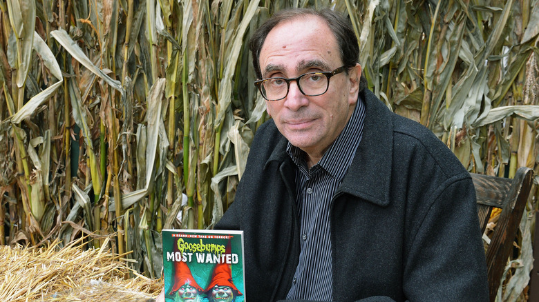 R.L. Stine in field holding Goosebumps