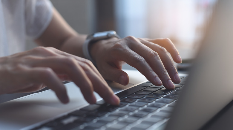 woman writing on computer