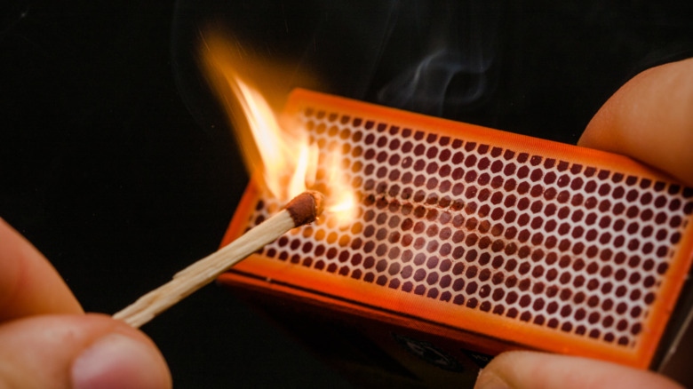 Person lighting a match