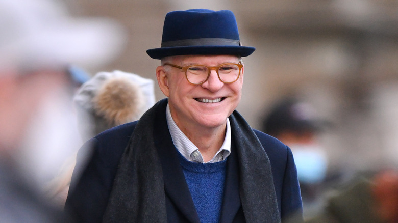 Steve Martin hat smiling in a blurred crowd