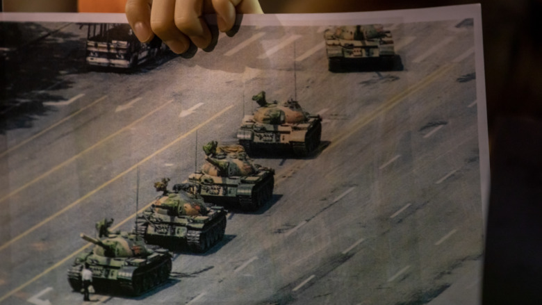 A  protester carrying a photo of Tank Man