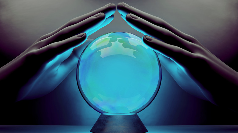 hands around crystal ball