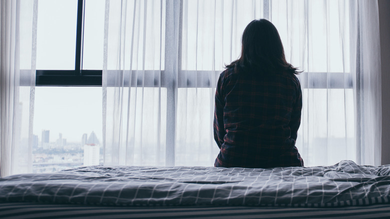 woman looks out a window