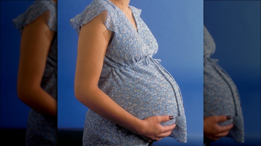 Pregnant woman holding her belly