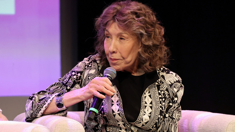 Lily Tomlin sitting on a couch and speaking in 2024