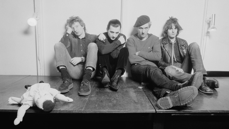 The Damned sitting on stage looking glum