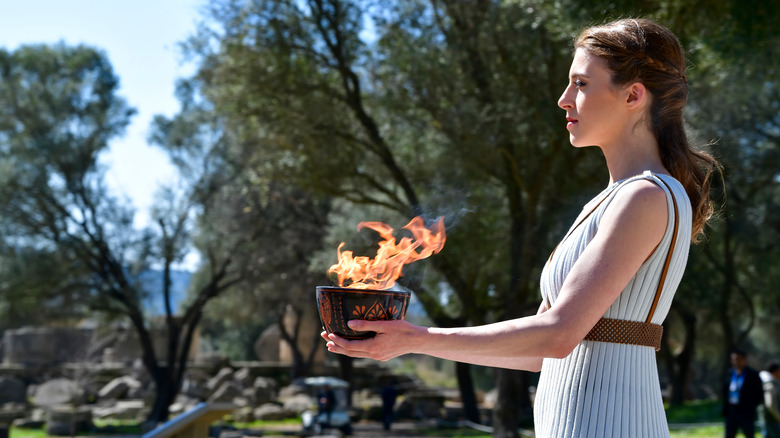 priestess handing over olympic flame