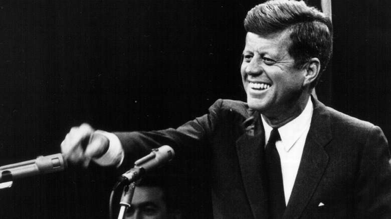 John F. Kennedy laughing at podium
