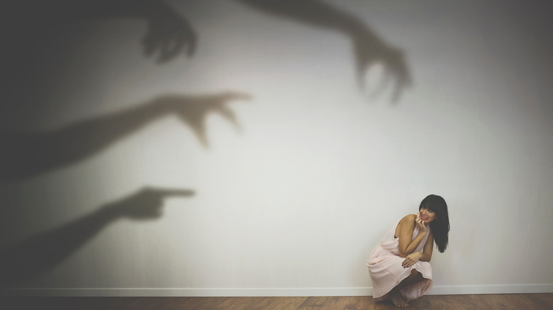 woman cowering from demons