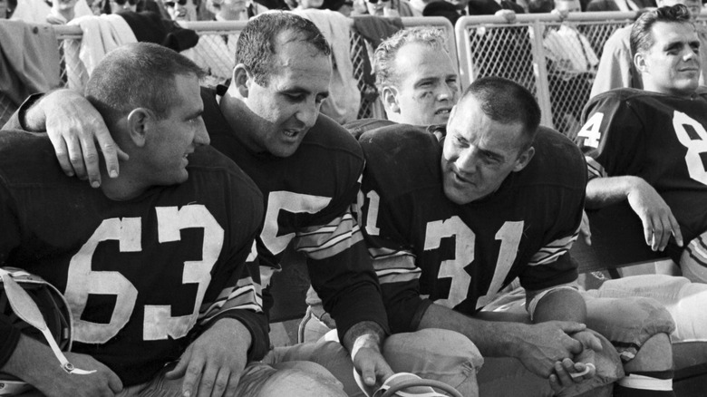 Max McGee sitting with teammates