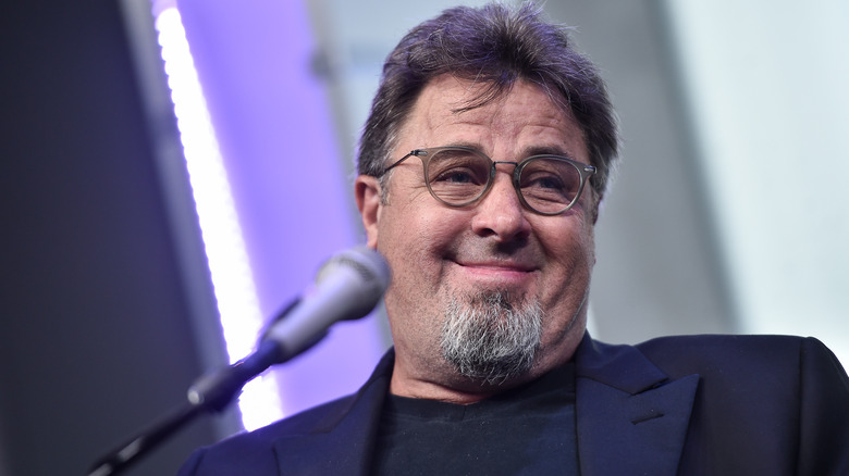 Vince Gill smiling behind mic