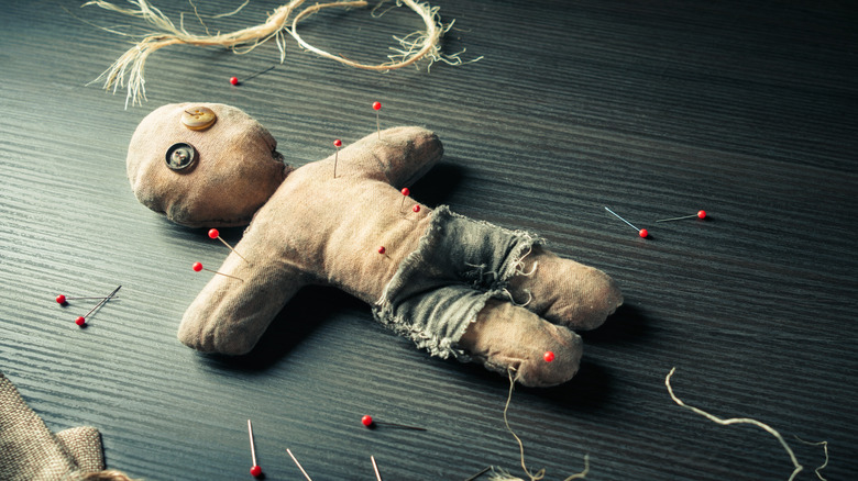 voodoo doll with pins in it