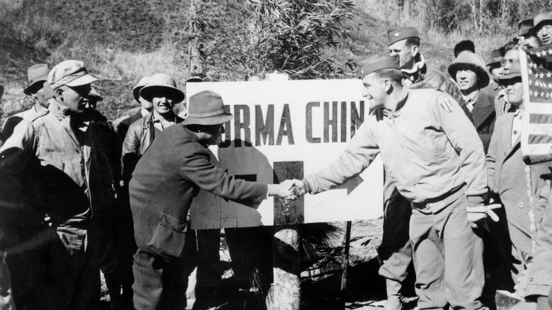 officials shake hands at the burma-china border immediately after the war