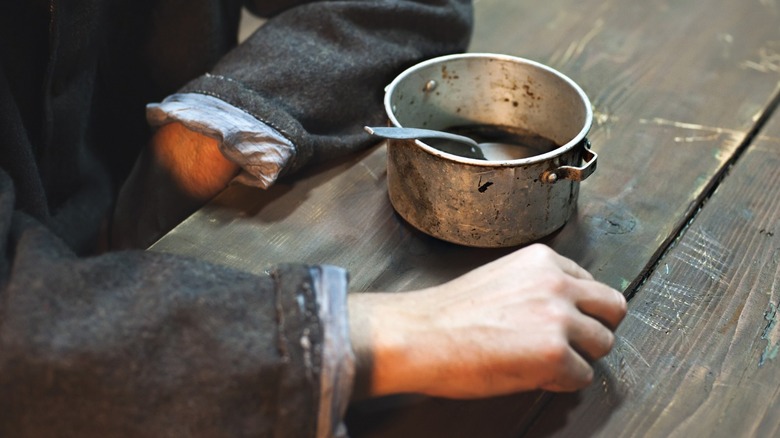 Prisoner's hands by a cup