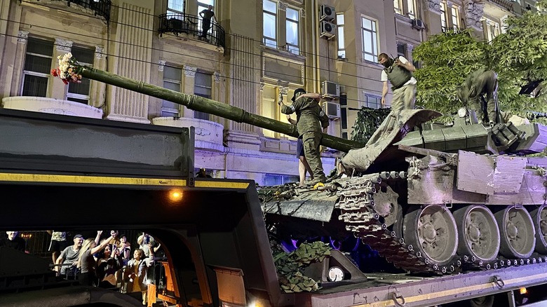 Russian civilian hugging Wagner soldier on tank