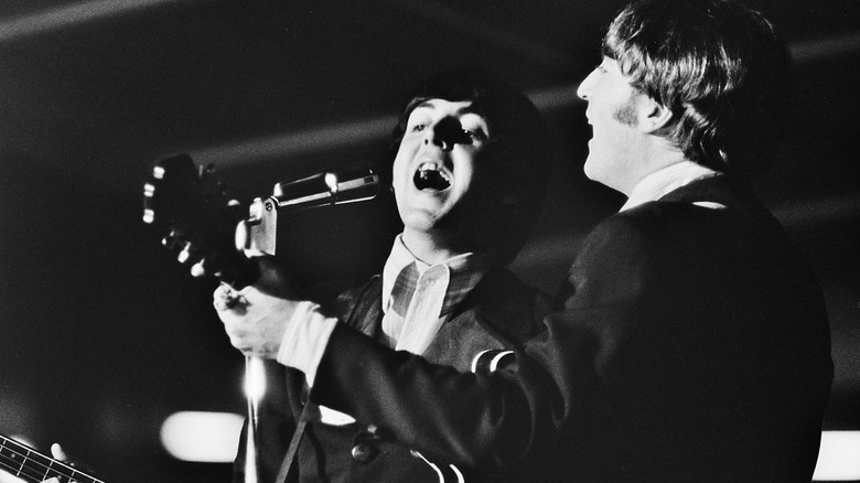 Paul McCartney and John Lennon singing with the Beatles.