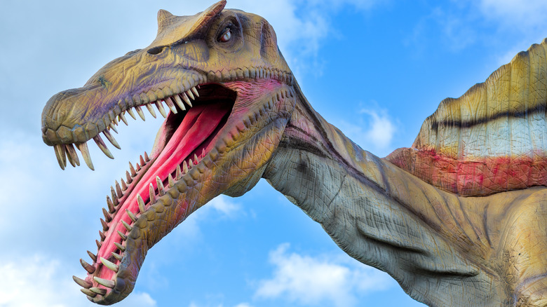 Spinosaurus statue with blue sky