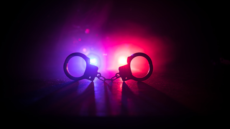 handcuffs illuminated by police car lights