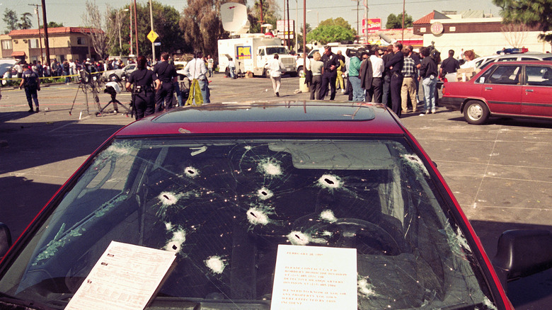 A bullet-riddled car and a crowd outside the Bank of America