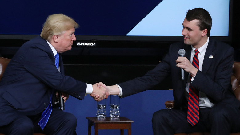Donald Trump shaking hands with Charlie Kirk