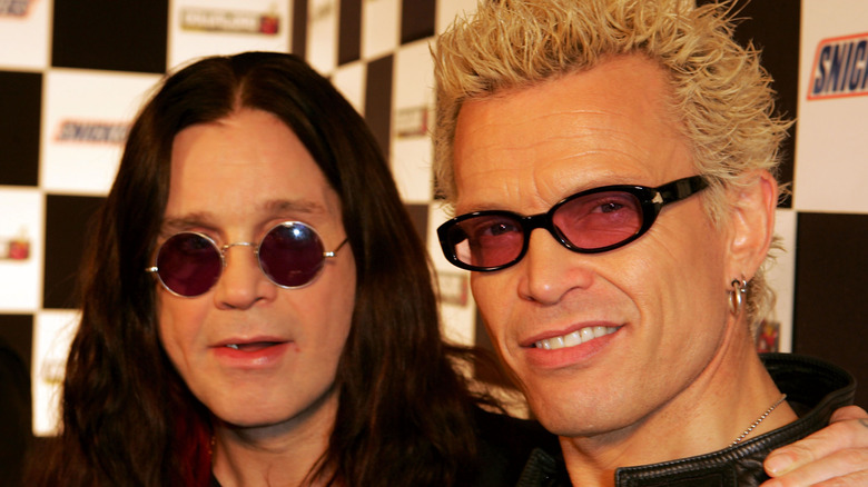 Ozzy Osbourne with his arm on shoulder of smiling Billy Idol