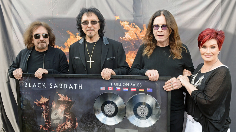 Geezer Butler, Tony Iommi, Ozzy Osbourne, Sharon Osbourne hold up an album sales plaque