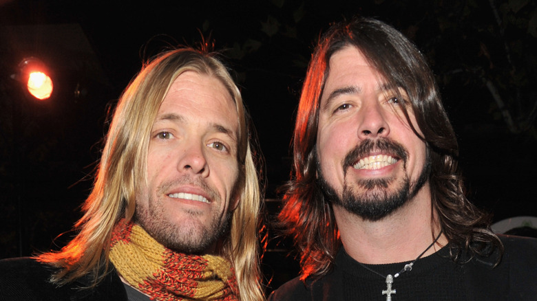Taylor Hawkins and Dave Grohl awkwardly smiling at camera