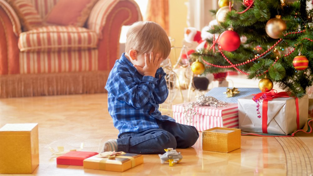 Little boy crying under Christmas tree