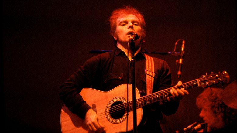 Van Morrison playing guitar and singing on stage in 1979