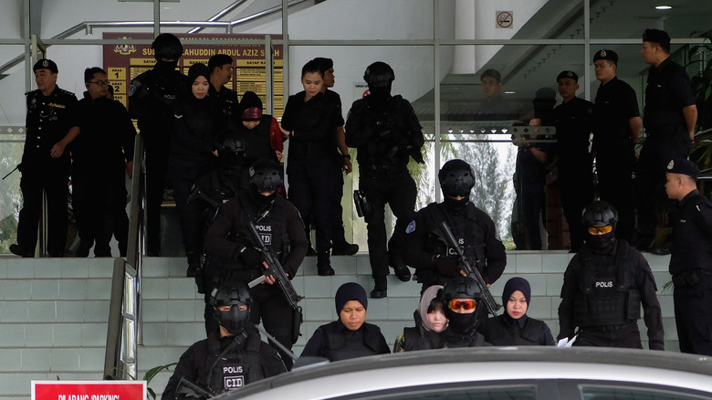 Duong Thi Huong and Siti Aisyah escorted by police