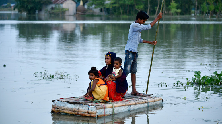 people rowing boat through flood