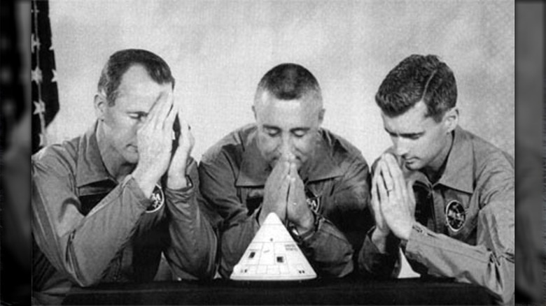 apollo 1 astronauts praying over miniature capsule