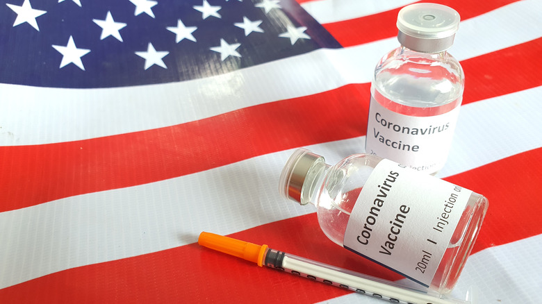 Bottles labeled Coronavirus Vaccine with syringe atop American flag
