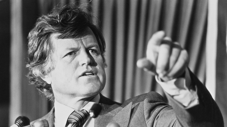 Edward Kennedy pointing in front of microphones