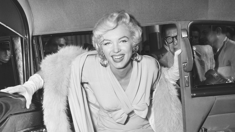 Marilyn Monroe smiling climbs out of car