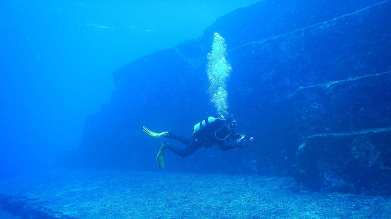 Diver in front of Yonaguni Monument underwater formation