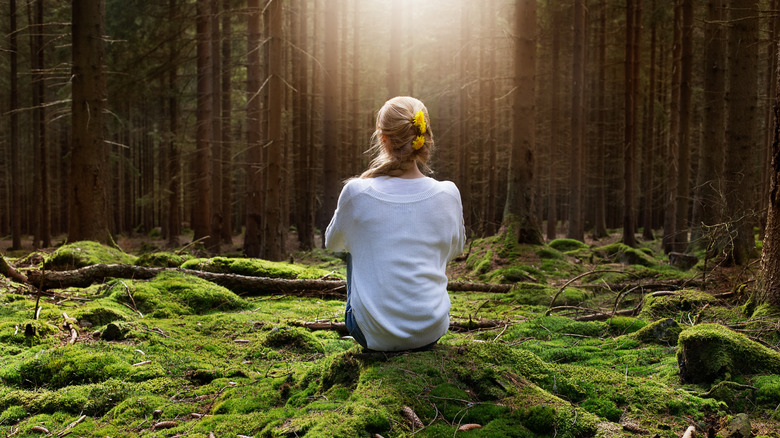 Woman sitting in forest