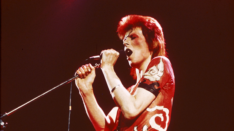 David Bowie on stage with microphone as Ziggy Stardust