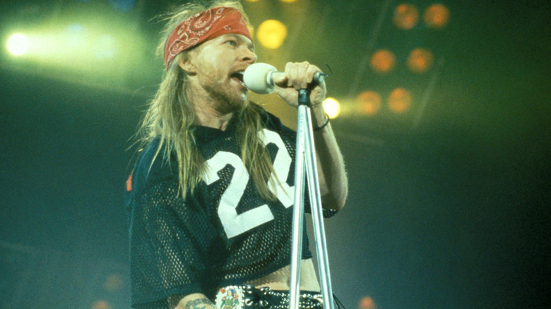 Guns N' Roses' Axl Rose singing into a microphone onstage