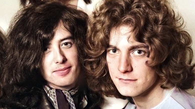 Jimmy Page and Robert Plant with faces close in Led Zeppelin publicity photo