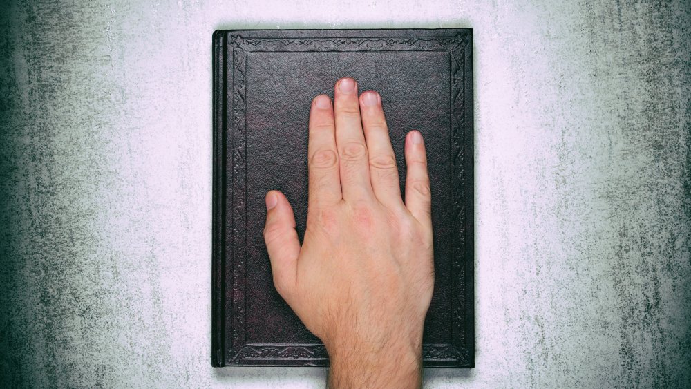 A person taking on oath on a Bible