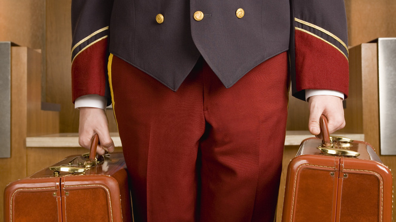 Vintage bellhop carrying suitcases