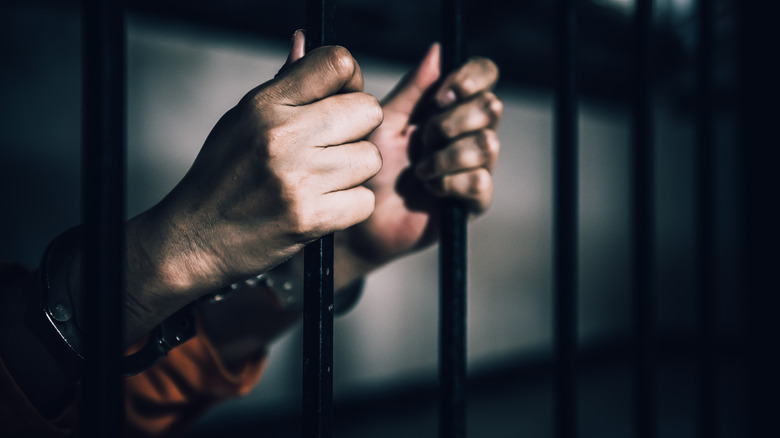 Prisoner holding jail cell bars